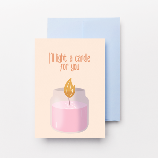 A greeting card with a light pink candle illustration and the text 'I'll light a candle for you' in orange, shown with a light blue envelope on a light gray background.