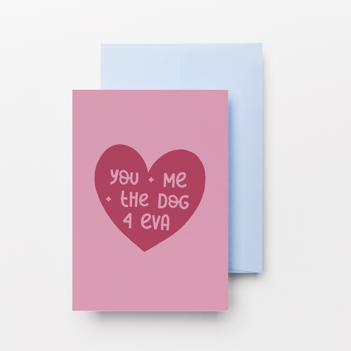A pink greeting card with a dark red heart graphic containing the text 'you - Me - the dog 4 eva' in pink, shown with a light blue envelope behind it on a clean white background.