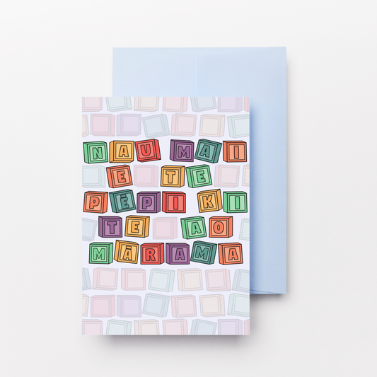 A greeting card with a colorful block-letter message on a pastel tiled background, shown with a light blue envelope behind it on a clean white background.